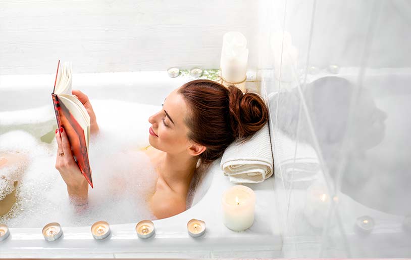 Une femme lit dans son bain